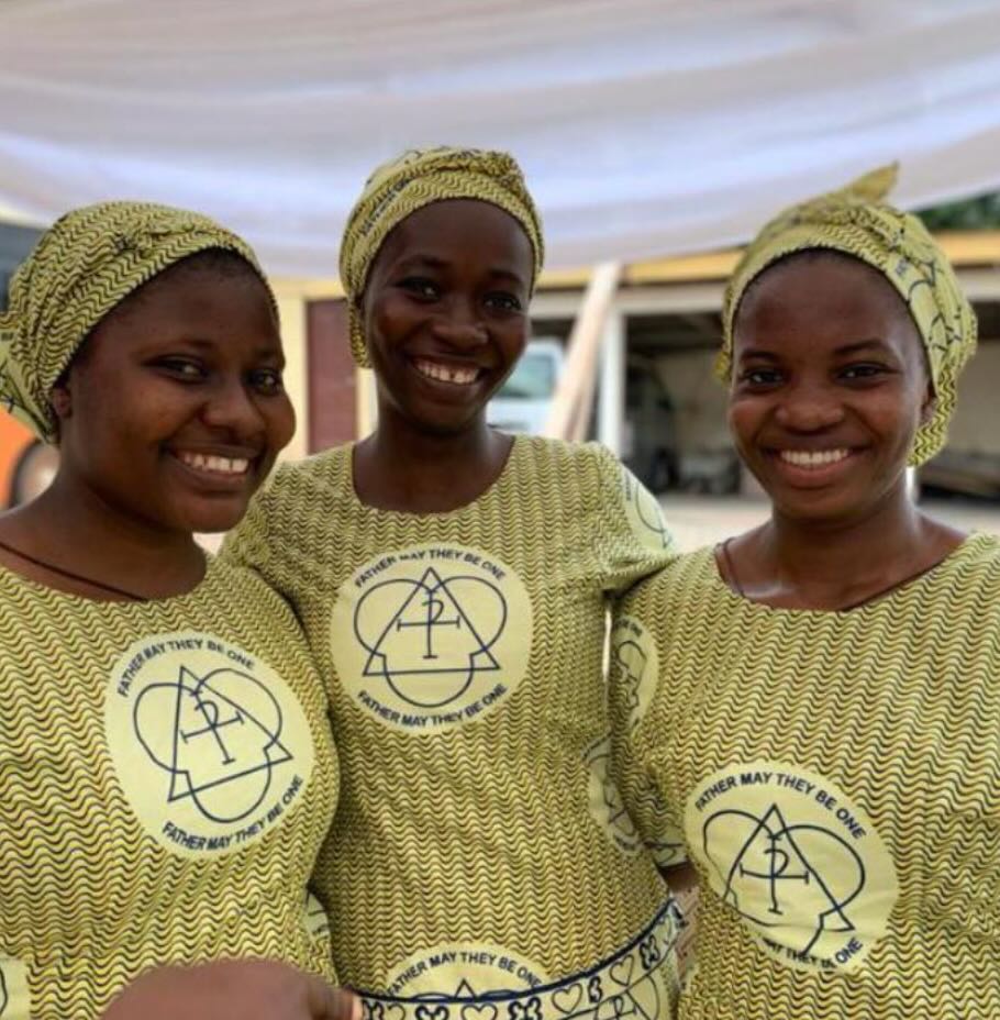 Young FST sisters smiling wearing green squiggly Trinity cloth, which forms part of a habit.