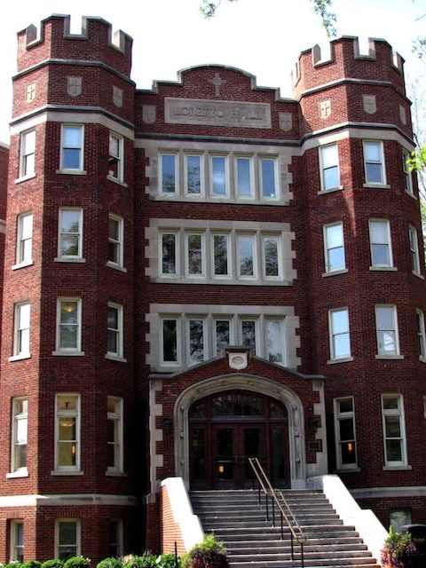 Photo of a brown five story building.