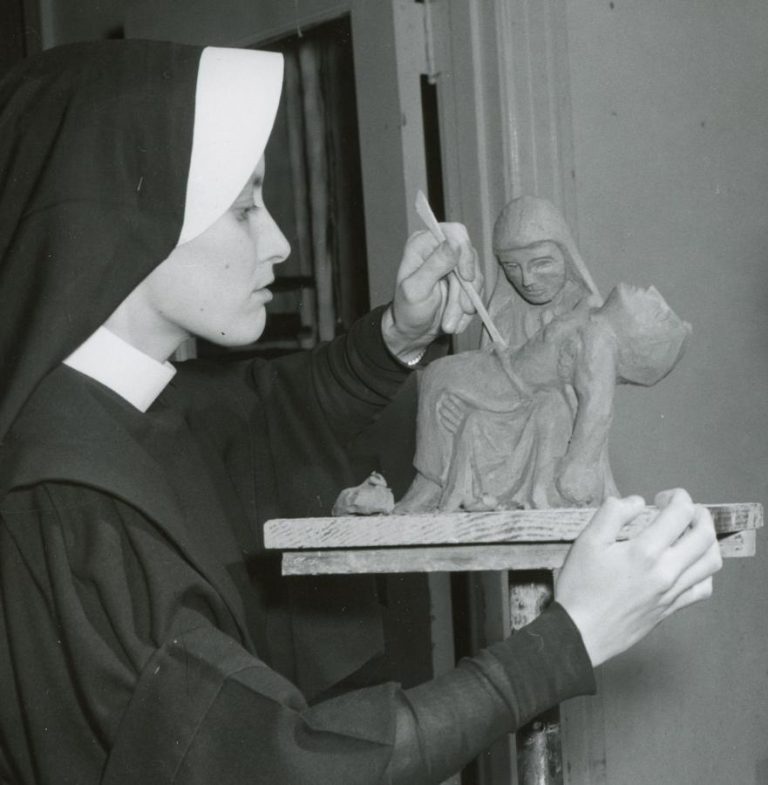 Archival photo of a habited nun sculpting the piéta.