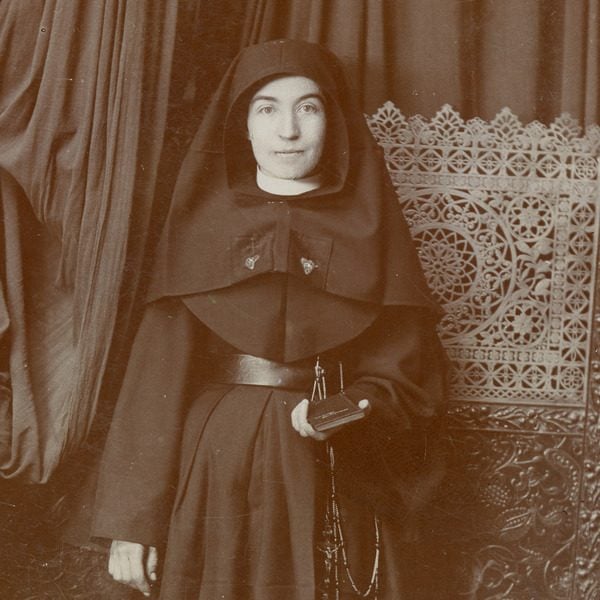 Archival formal photo of a young Sister Lucia Perea in habit holding her bible and posing.