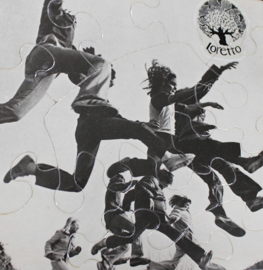 Puzzle made from a photo looking up at children leaping. A circular logo of a tree with "Loretto" underneath is visible in the upper right corner.