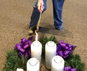 Hand lighting an Advent wreath