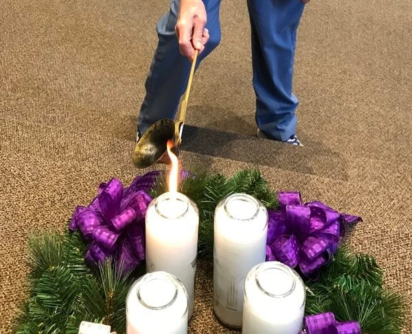 Hand lighting an Advent wreath