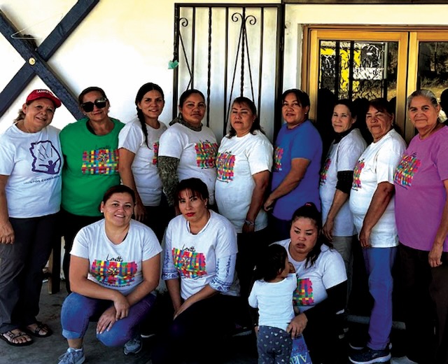 A group of community center volunteers in Mexico proudly sport Loretto Community t-shirts.
