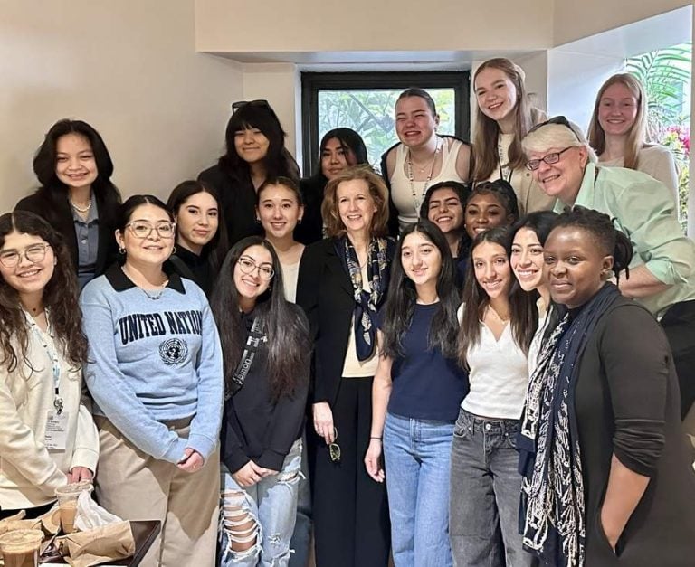 A diverse group of young women gathers with Irish Ambassador Lisa Carty and Loretto at the UN representative Beth Blissman for a photo.