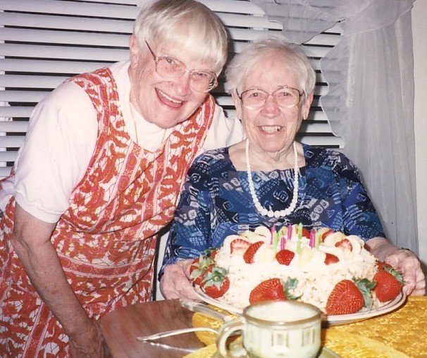 Cecily Jones SL and Mary Luke Tobin SL smile while posed with a strawberry birthday cake.