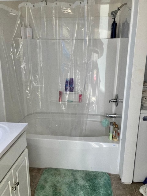 A photo of a white tub and shower with a plastic shower lining and a green rug below.