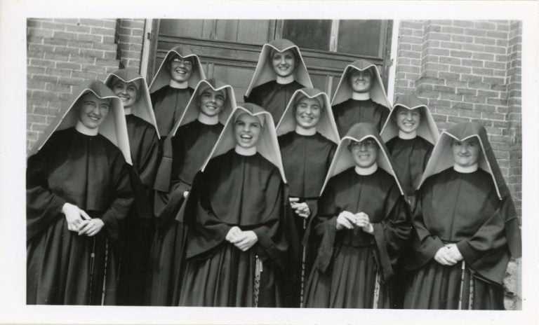 Archival photo of the 1949 Loretto Heights College reception class - eleven women in habits posing for a photo with joyous expressions on their faces.