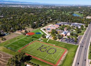 Bird's eye view of St. Mary's Academy with the "160" spelled out by the student body on the soccer field. The Denver skyline and the Rocky Mountains are visible in the background.