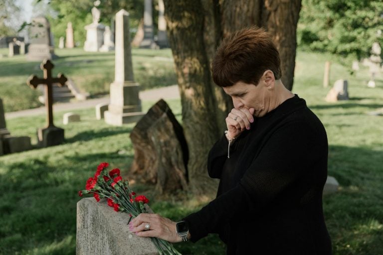 a woman holding flowers at the cemetery