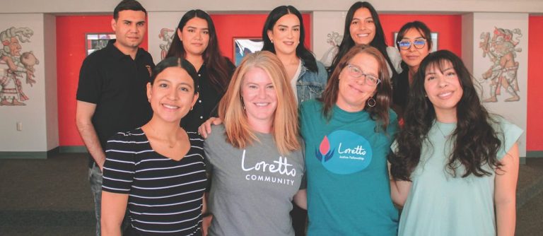 A group of nine people smiling in a group.