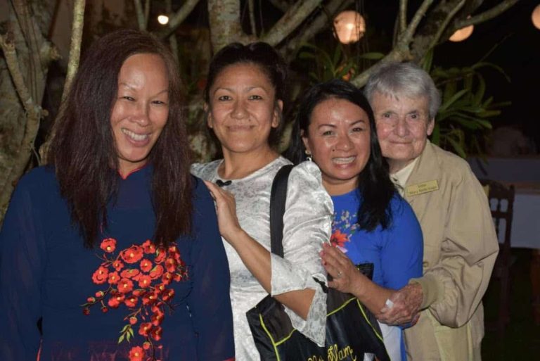 Three Vietnamese former adoptee women and a religious sister smile for a photo.
