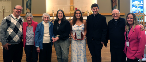 A group of young, middle aged and older women and men pose at an award ceremony