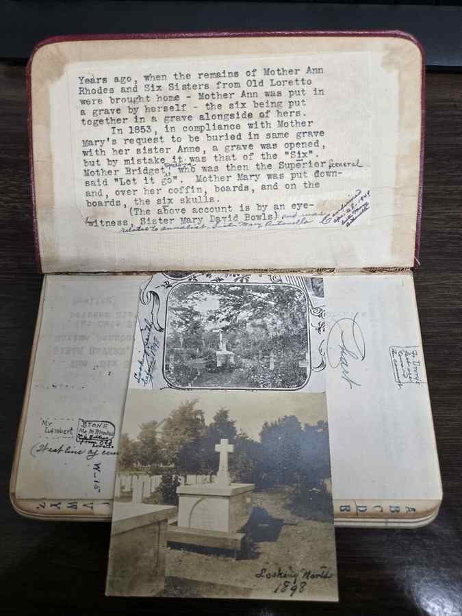 Open notebook with typed text affixed to the front cover and a photo of a large grave marker below.