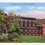 A postcard of a red brick building that used to house students and classrooms.
