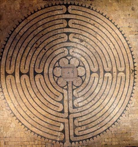A circular chartres labyrinth design on light wood.