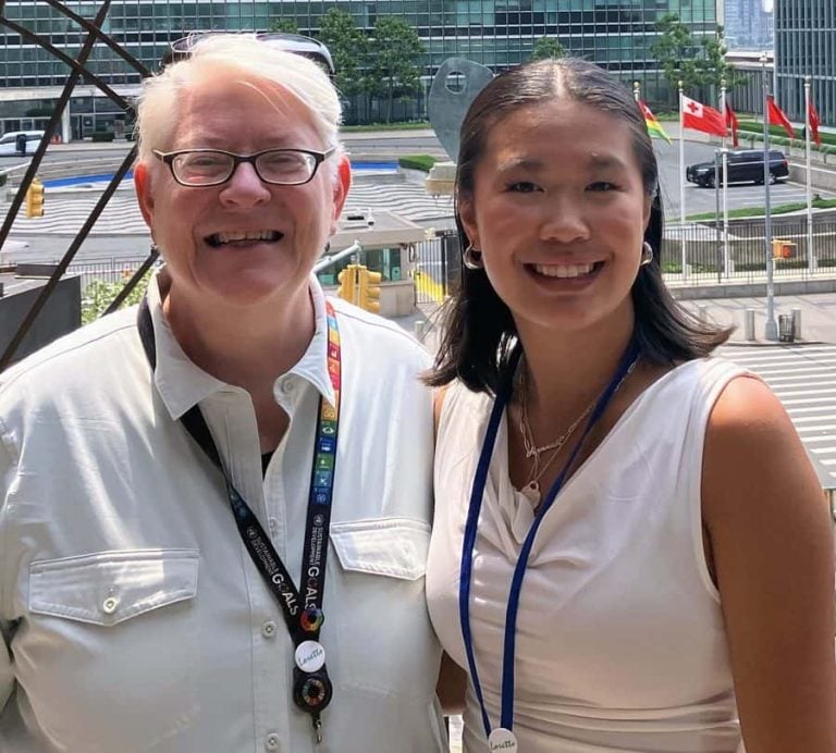 Two women pose for a photo together outside the United Nations.