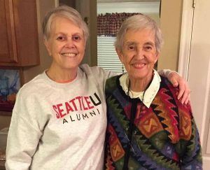 Lillian Moskeland CoL slings her arm over the shoulder of her sister, Mary Peter Bruce SL, as they smile for a photo together.