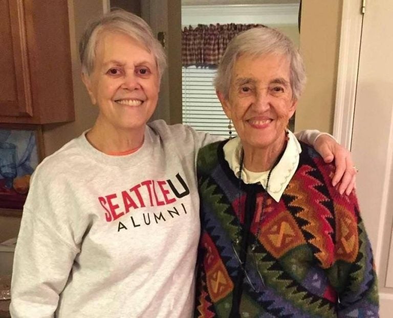 Lillian Moskeland CoL slings her arm over the shoulder of her sister, Mary Peter Bruce SL, as they smile for a photo together.