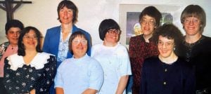 A photo of residents at the Bridge Community in Denver from the 1990s smiling together.