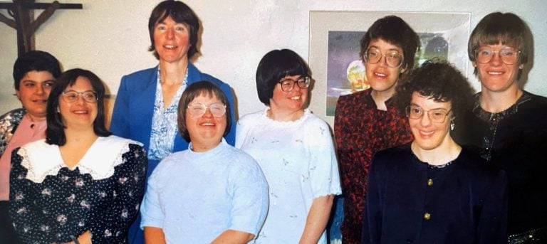 A photo of residents at the Bridge Community in Denver from the 1990s smiling together.