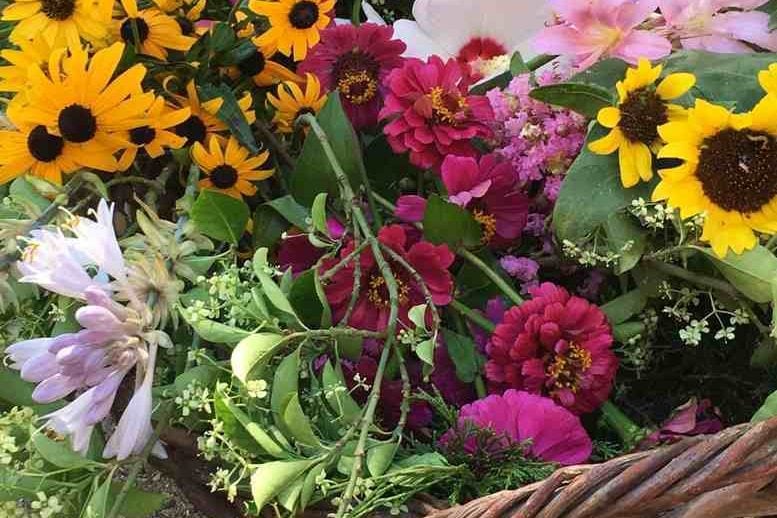 A wicker basket full of colorful flowers.