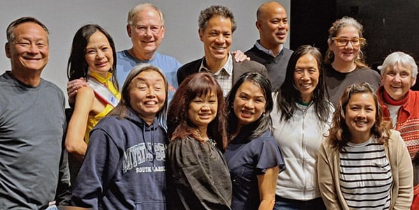 A smiling group of mixed-race people pose for a photo