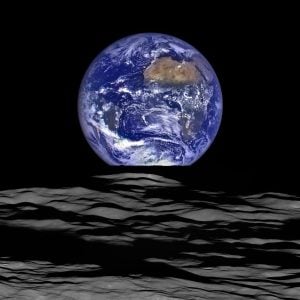 A clear photo of the blue earth rising over the moon in space.