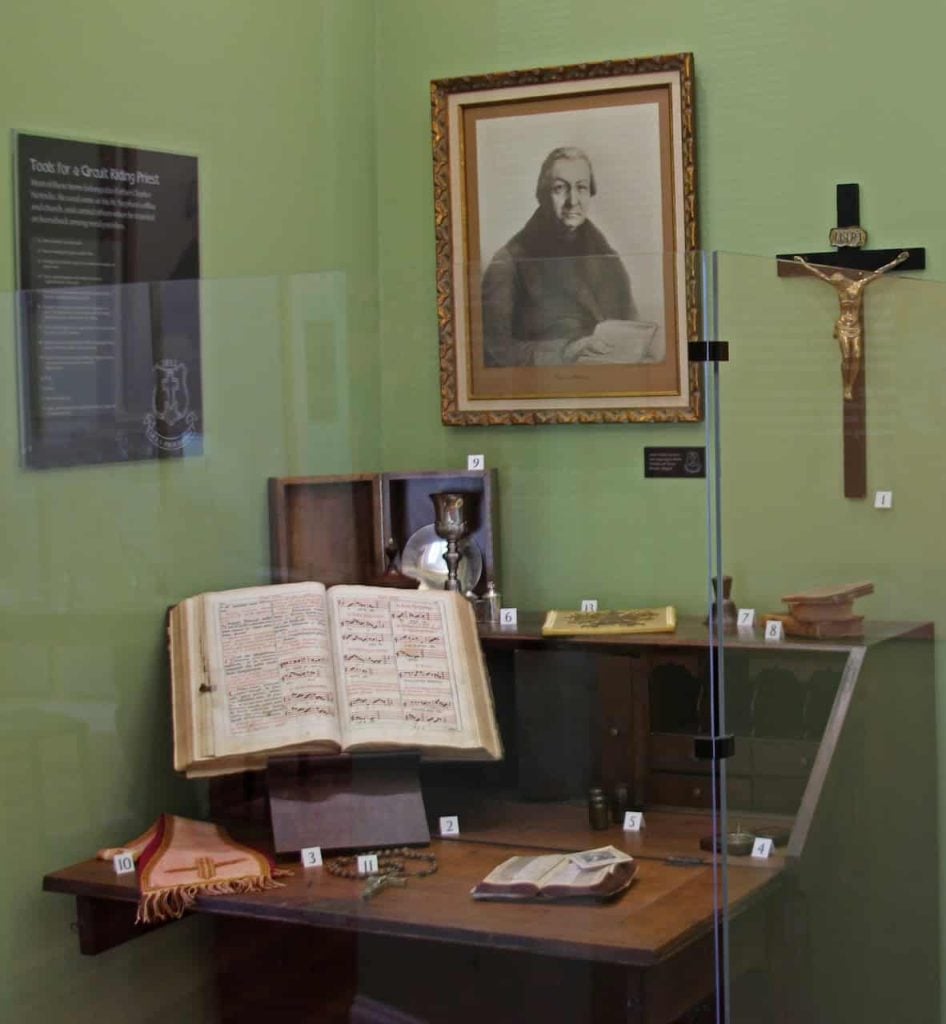 Rev. Charles Nerinckx's desk and various personal items are displayed in the Loretto Heritage Center behind glass.