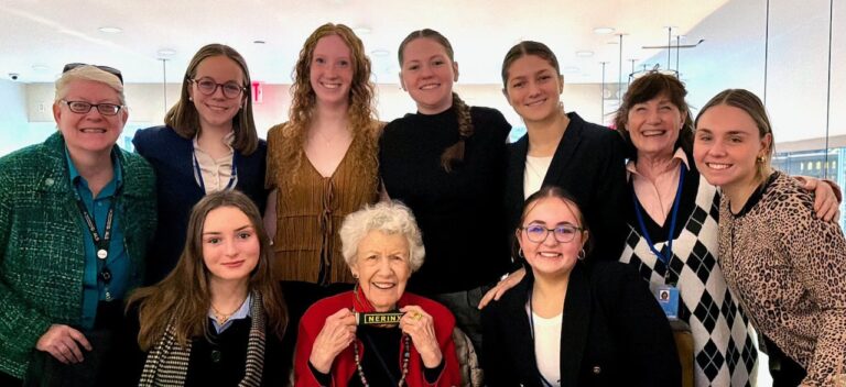 A group of high school students and three adults smiling for a picture together at the United Nations Commission on the Status of Women 2026.