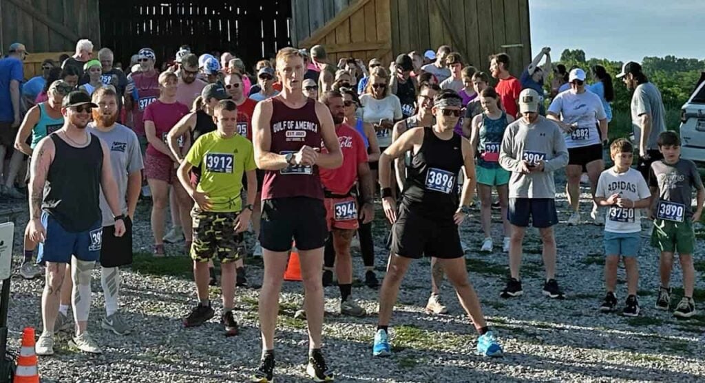 Runners of all different ages in a crowd at the starting line of a 5k race.