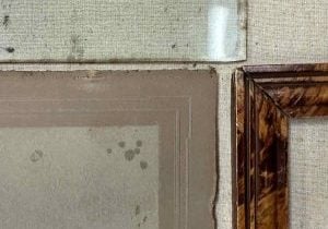The corners of a frame, old stained matboard and spotted frame glass come together in this photo.