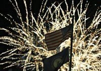 Fireworks backlight the American and Kentucky flags