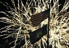 Fireworks backlight the American and Kentucky flags