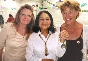Three women lean in for a photo together at a celebration