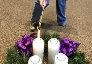 Hand lighting an Advent wreath