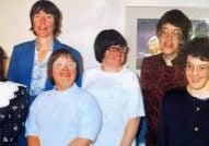 A photo of residents at the Bridge Community in Denver from the 1990s smiling together.