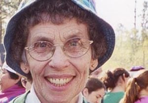 A photo of Loretto Co-member Peg Jacobs smiling and wearing a colorful hat