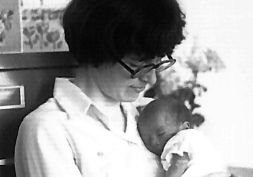 A woman cradles a dozing infant in this archival photo.
