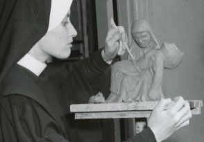 Archival photo of a habited nun sculpting the piéta.