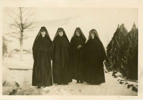 Four Sisters of Loretto stand side by side in the snow in heart shaped habits.