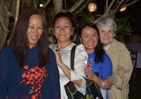 Three Vietnamese former adoptee women and a religious sister smile for a photo.
